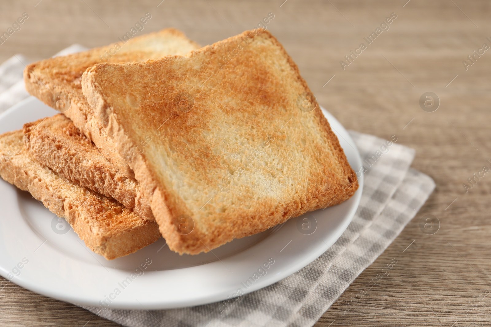 Photo of Slices of delicious toasted bread on wooden table, closeup