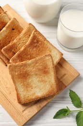 Photo of Delicious toasts with milk on white wooden table