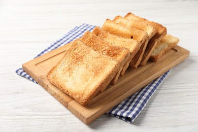 Photo of Slices of delicious toasted bread on white wooden table