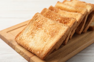 Photo of Delicious toasts on white wooden table, closeup