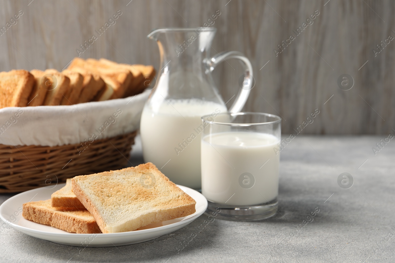 Photo of Delicious toasts served with milk on light table