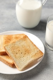 Photo of Delicious toasts with milk on light table, closeup