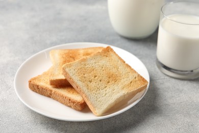 Photo of Delicious toasts with milk on light table