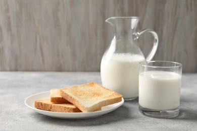 Photo of Delicious toasts with milk on light table