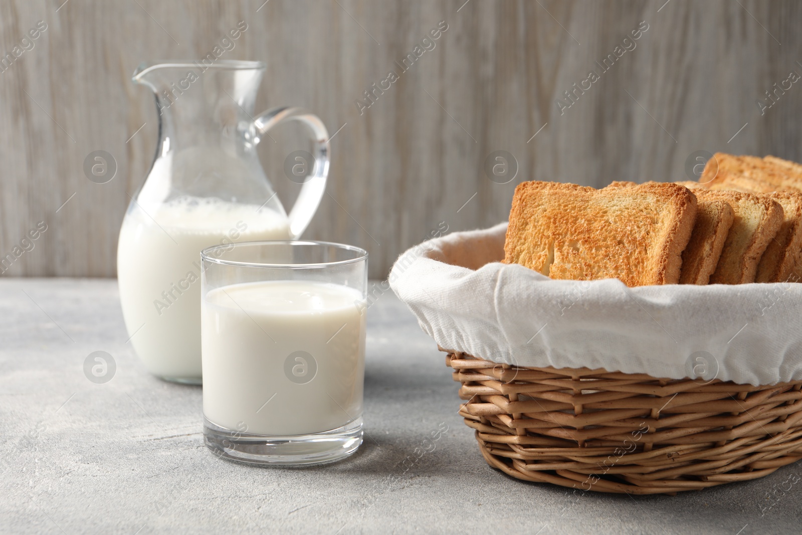 Photo of Delicious toasts with milk on light table