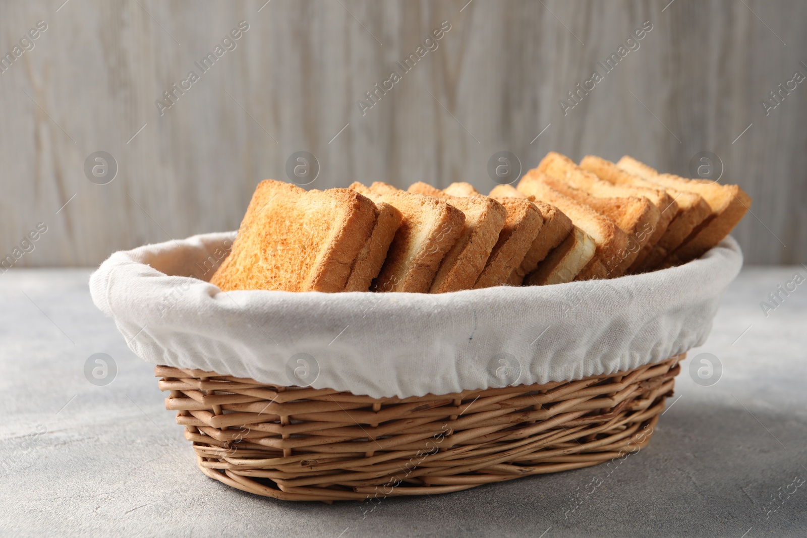 Photo of Delicious toasts in basket on light table