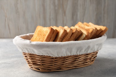 Photo of Delicious toasts in basket on light table