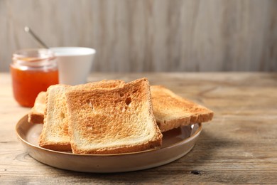 Slices of delicious toasted bread served on wooden table. Space for text