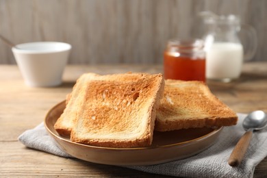 Slices of delicious toasted bread served on wooden table