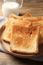 Photo of Delicious toasts served on wooden table, closeup