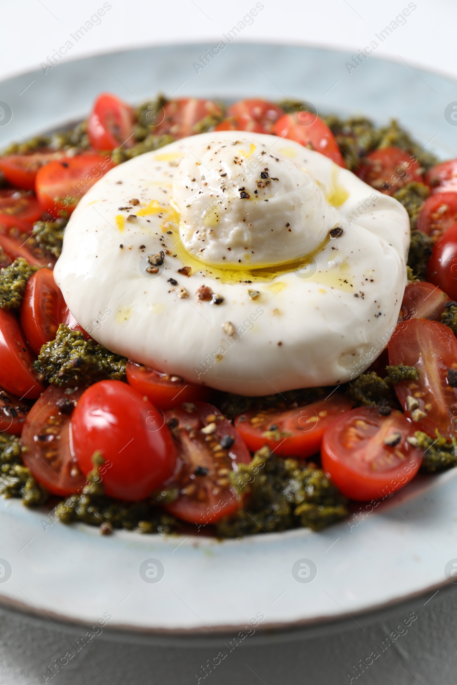 Photo of Fresh delicious burrata salad on table, closeup