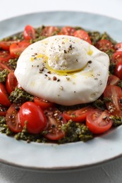 Photo of Fresh delicious burrata salad on table, closeup