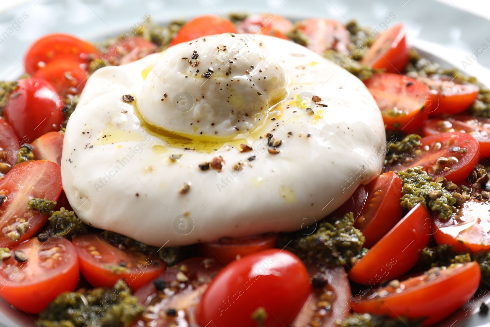 Photo of Fresh delicious burrata salad on plate, closeup