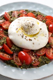 Photo of Fresh delicious burrata salad on table, closeup