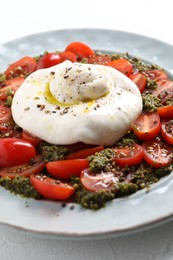 Fresh delicious burrata salad on table, closeup