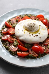 Photo of Fresh delicious burrata salad on light grey table, closeup