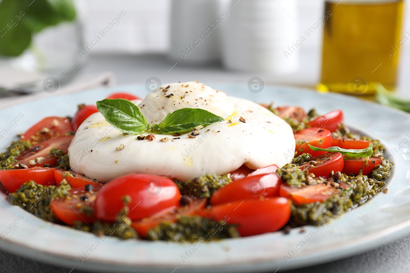 Photo of Fresh delicious burrata salad on table, closeup