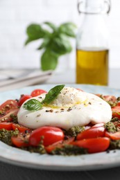 Fresh delicious burrata salad served on table, closeup