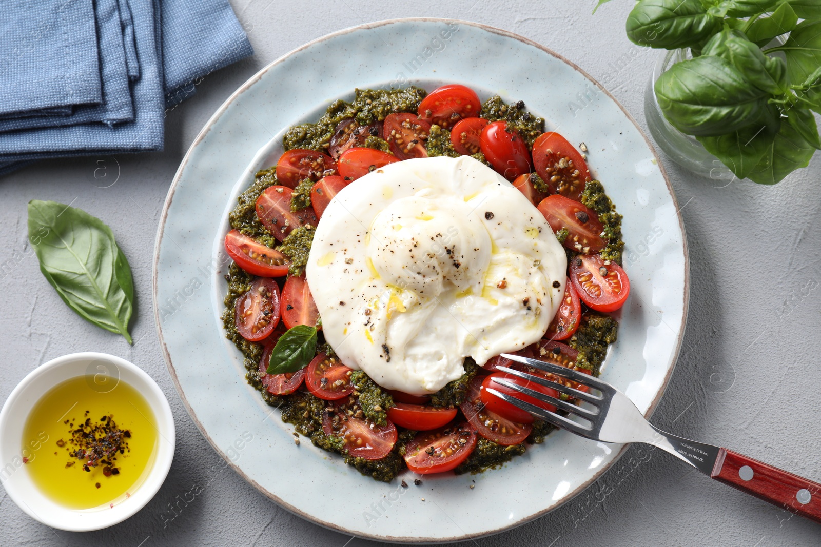 Photo of Fresh delicious burrata salad served on light grey table, top view