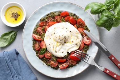 Photo of Fresh delicious burrata salad served on light grey table, top view