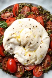 Fresh delicious burrata salad on plate, top view