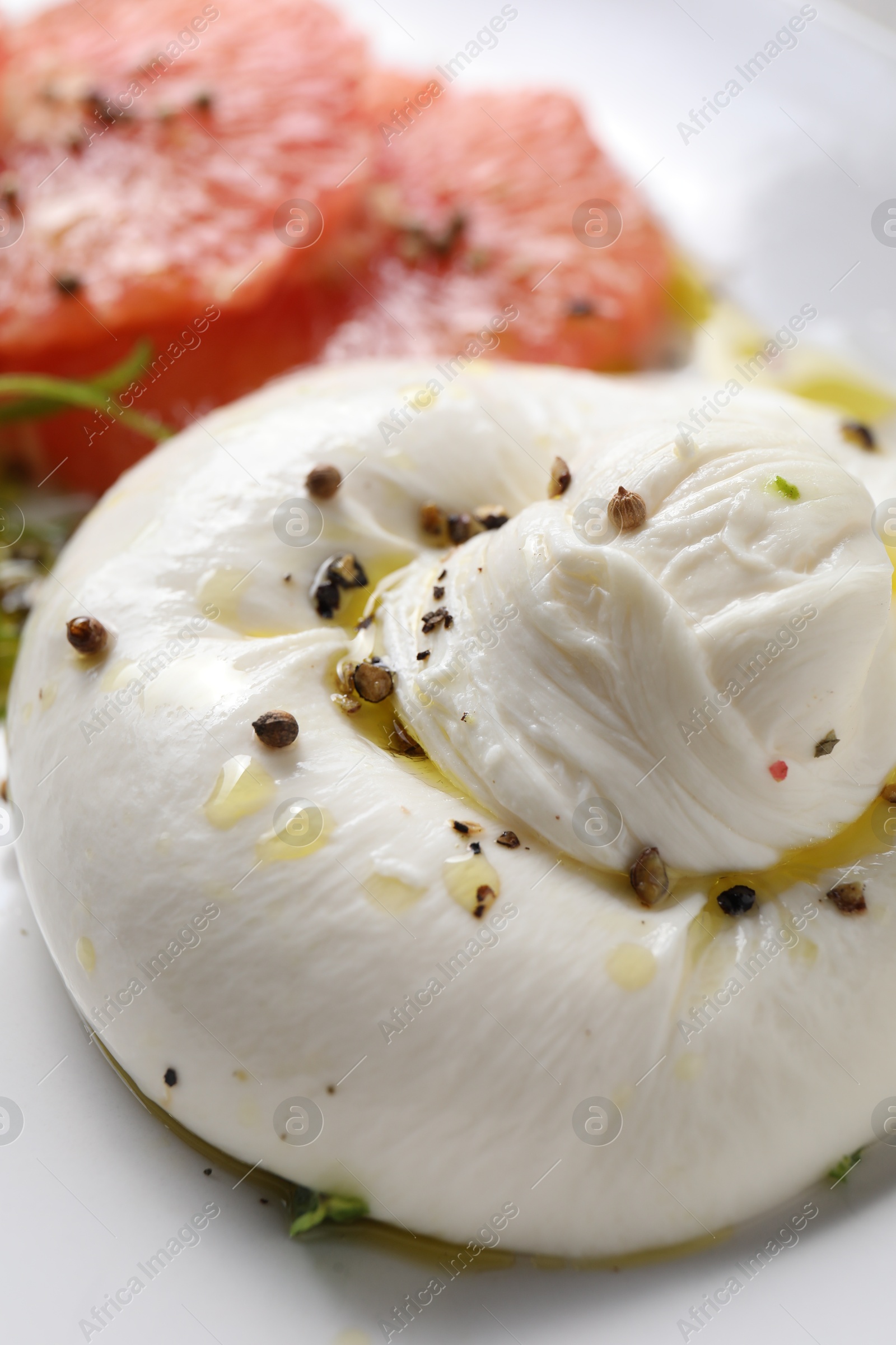 Photo of Delicious burrata cheese and spices on plate, closeup