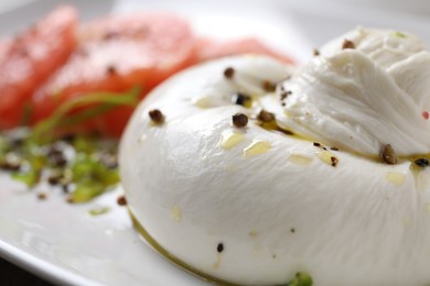 Photo of Delicious burrata cheese and spices on plate, closeup