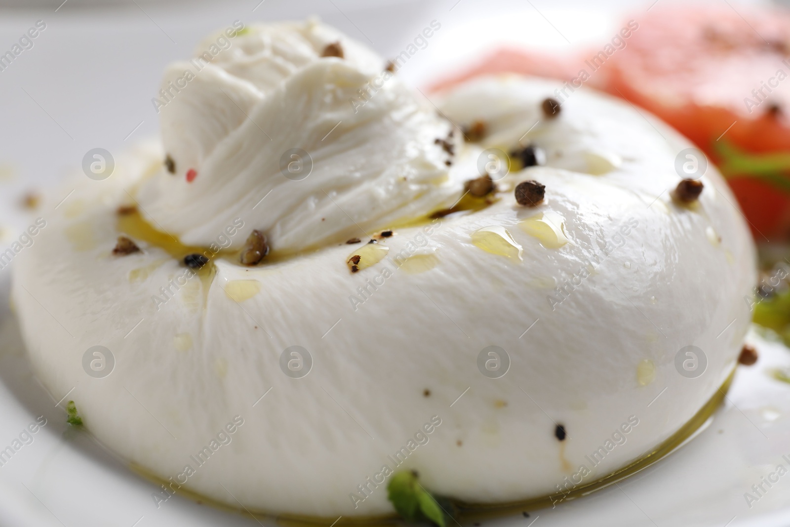 Photo of Delicious burrata cheese and spices on plate, closeup