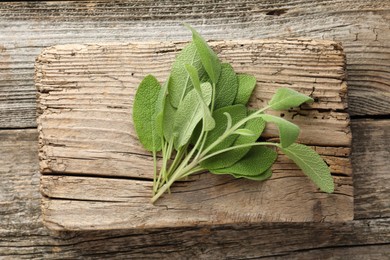 Photo of Fresh sage leaves on wooden table, top view