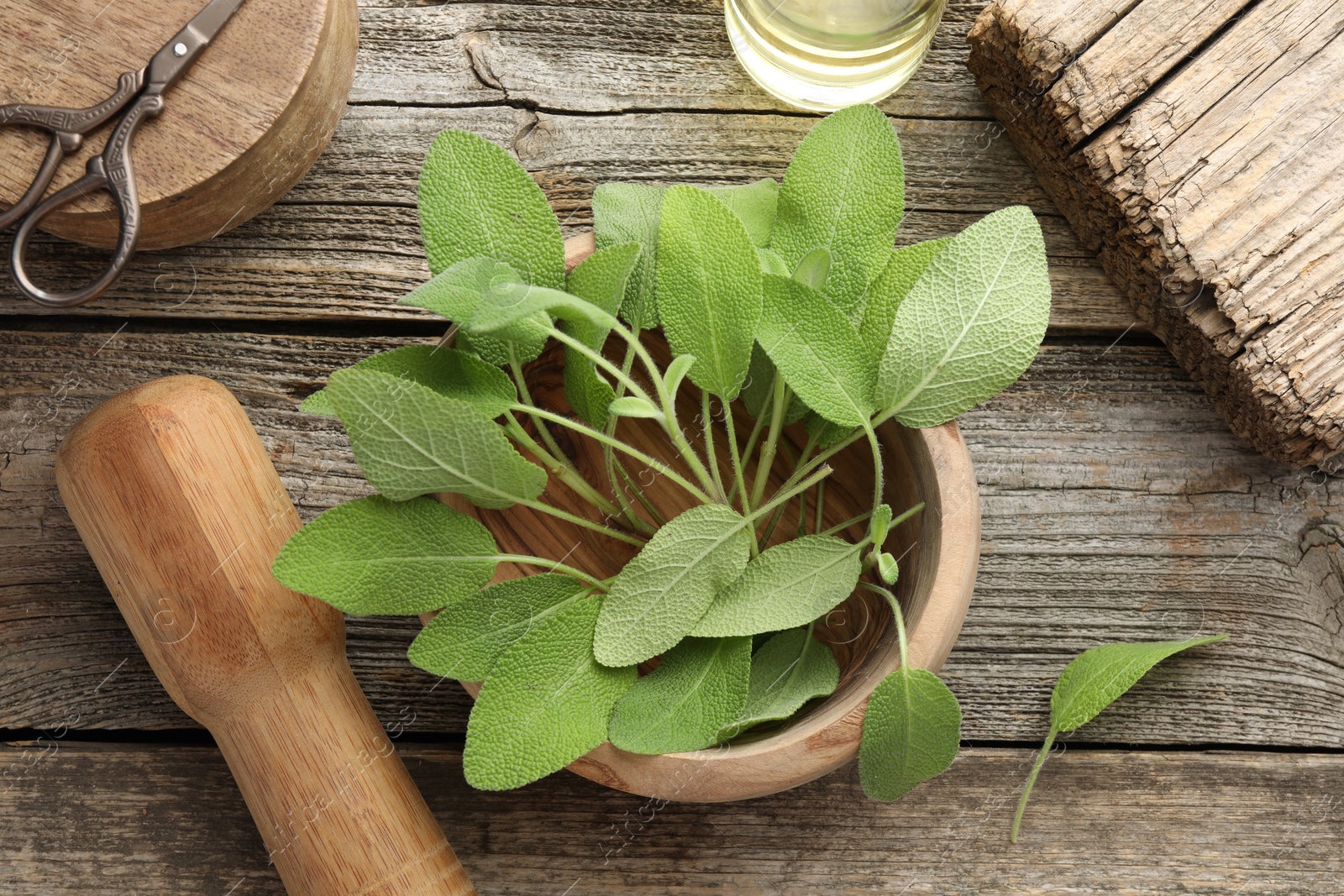 Photo of Fresh sage leaves, mortar, pestle and scissors on wooden table, flat lay