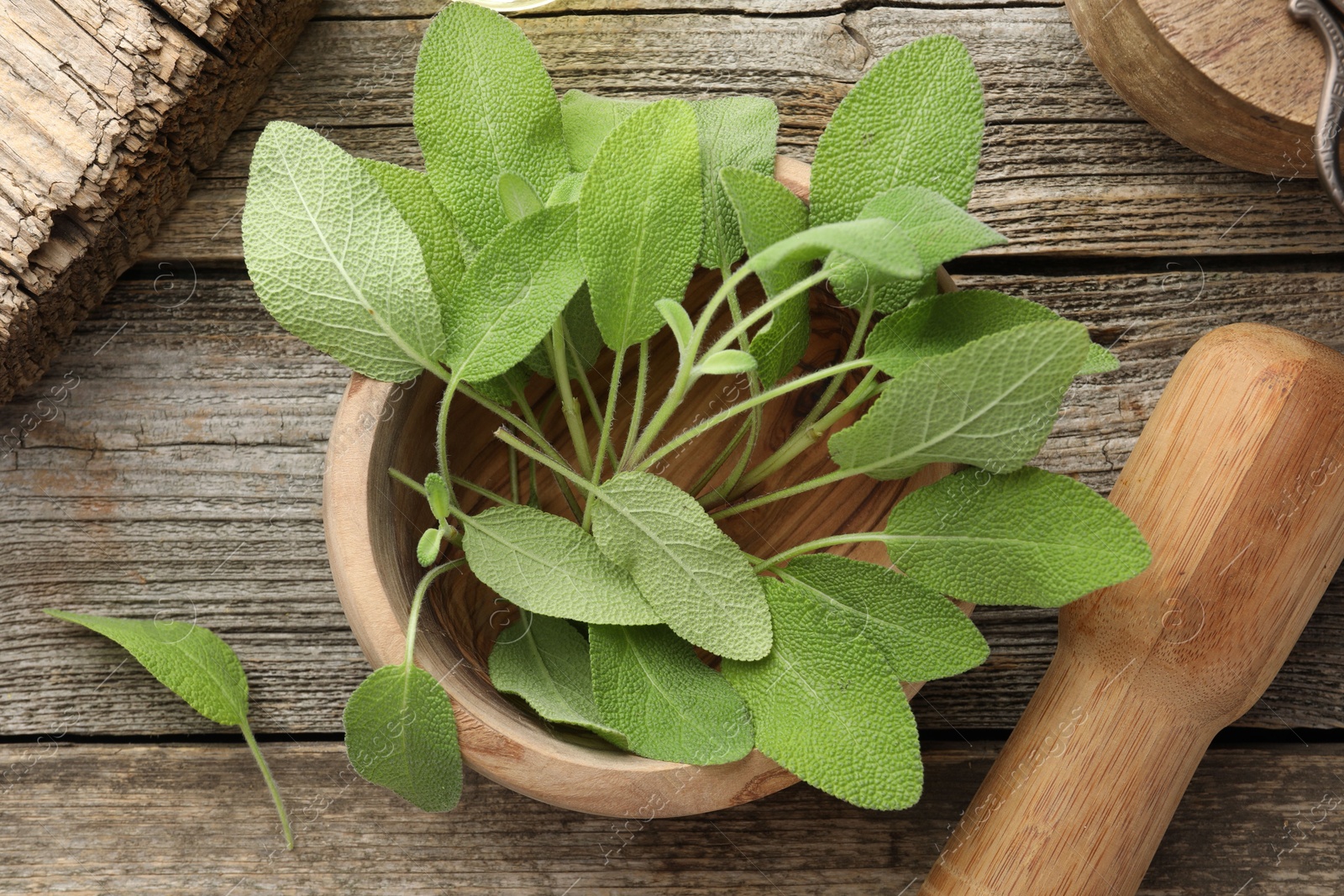 Photo of Fresh sage leaves, mortar and pestle on wooden table, flat lay