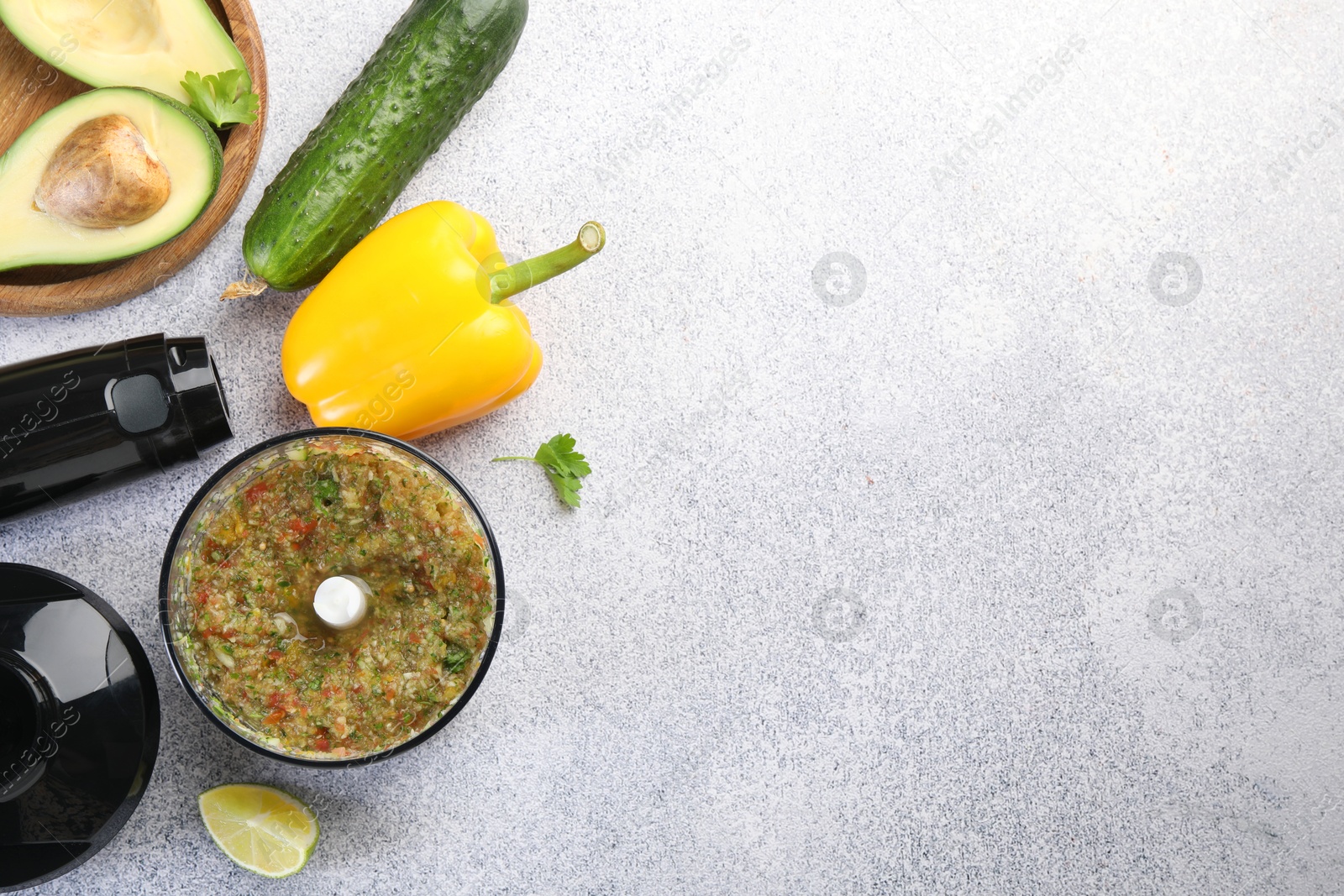 Photo of Hand blender kit, mixture of ingredients and fresh products on light grey table, flat lay. Space for text