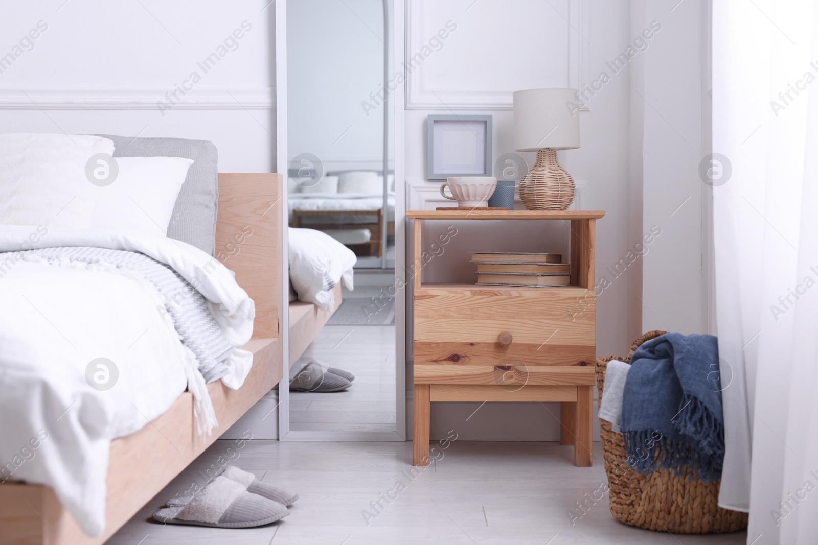 Photo of Stylish living room interior with bed, bedside table and lamp