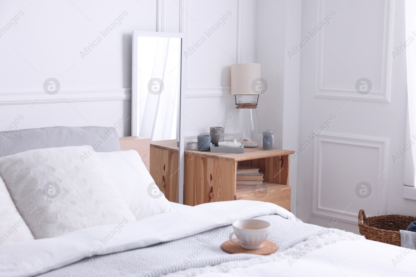 Photo of Stylish living room interior with bed, bedside table and lamp