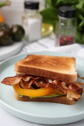 Photo of Tasty sandwich with bacon and bell pepper on white table, closeup