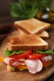 Photo of Tasty sandwich with bacon and tomato on table, closeup