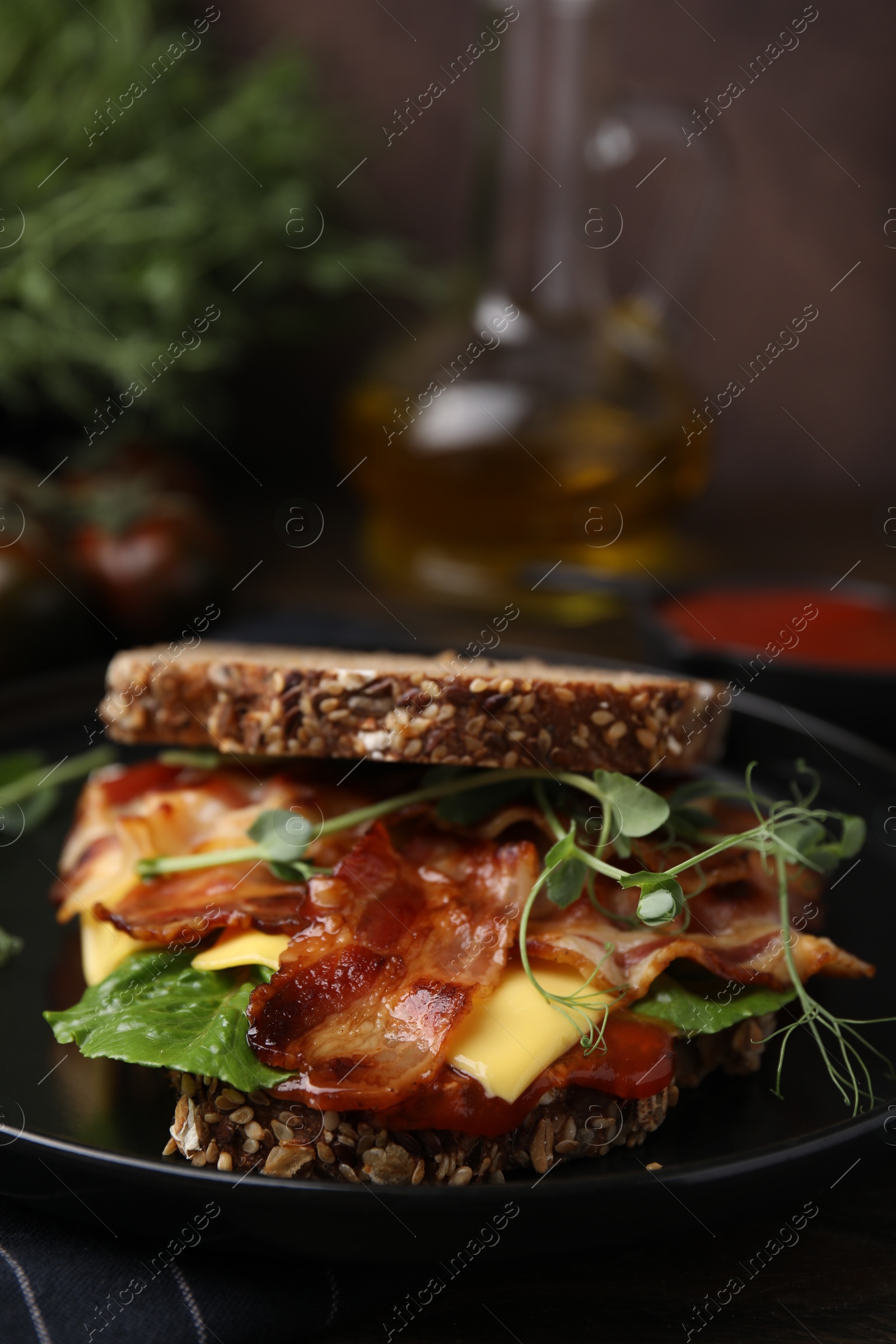 Photo of Tasty sandwich with bacon and cheese on table, closeup