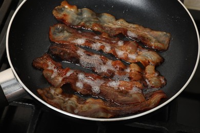 Photo of Slices of bacon frying in pan, closeup