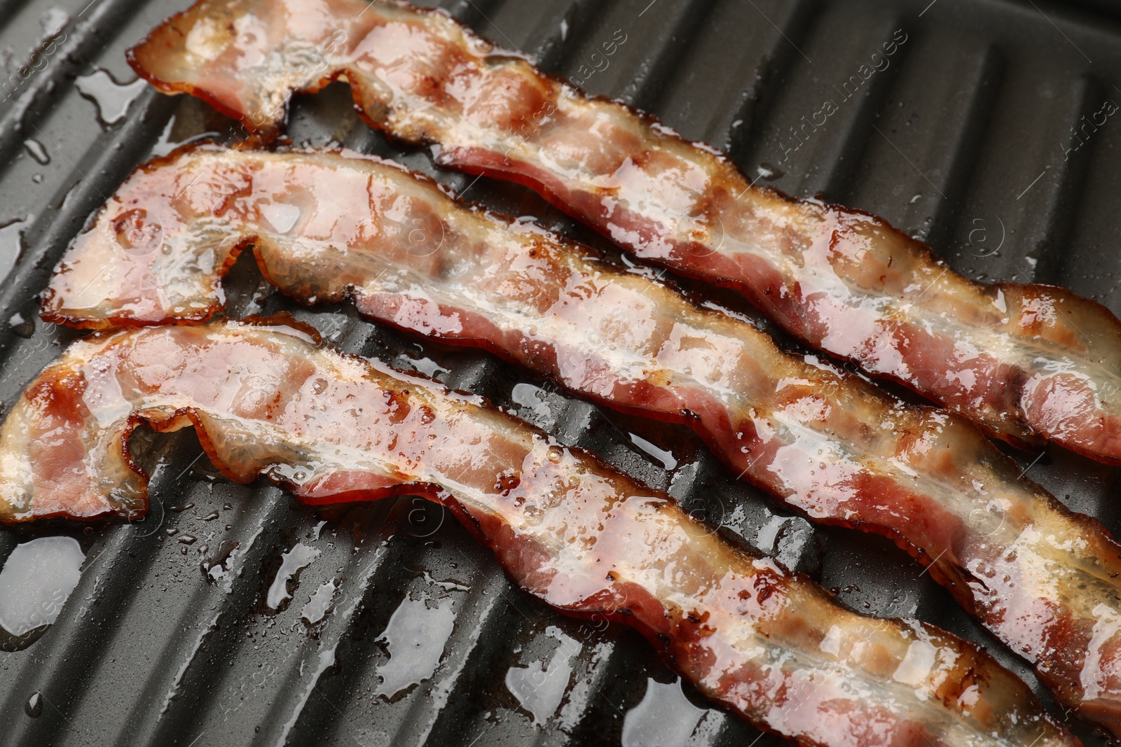 Photo of Slices of bacon on grill, closeup view