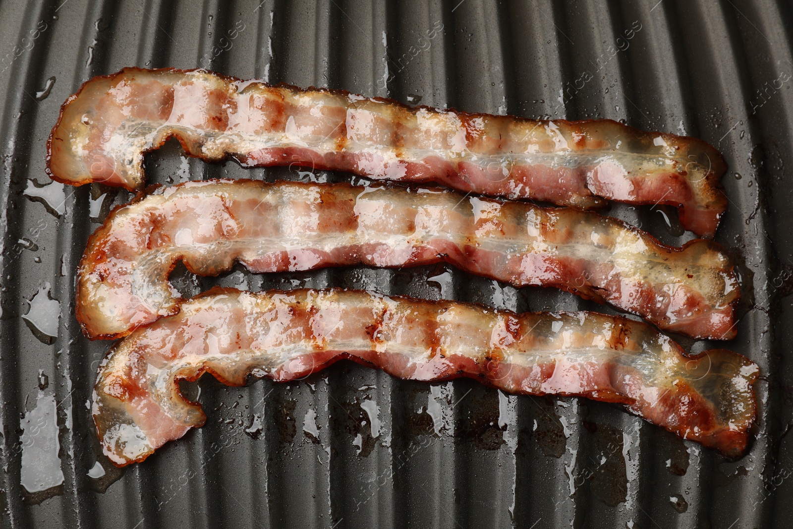 Photo of Slices of bacon on grill, top view