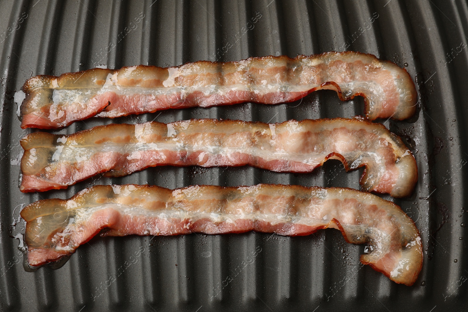 Photo of Slices of bacon on grill, top view