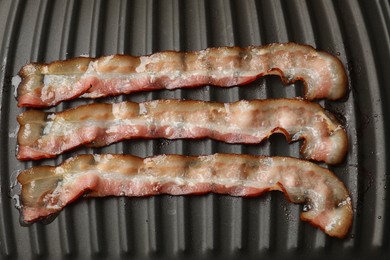 Slices of bacon on grill, top view