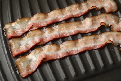 Slices of bacon on grill, above view