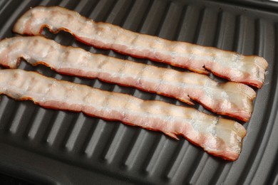 Slices of bacon on grill, closeup view