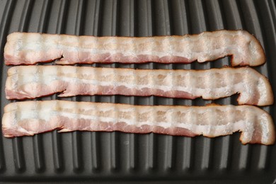 Slices of bacon on grill, top view