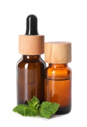 Bottles of essential oils and mint isolated on white