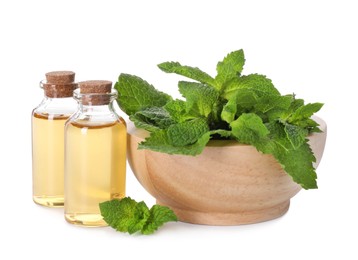 Bottles of essential oils and mint isolated on white