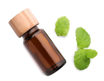 Photo of Bottle of essential oil and mint isolated on white, top view