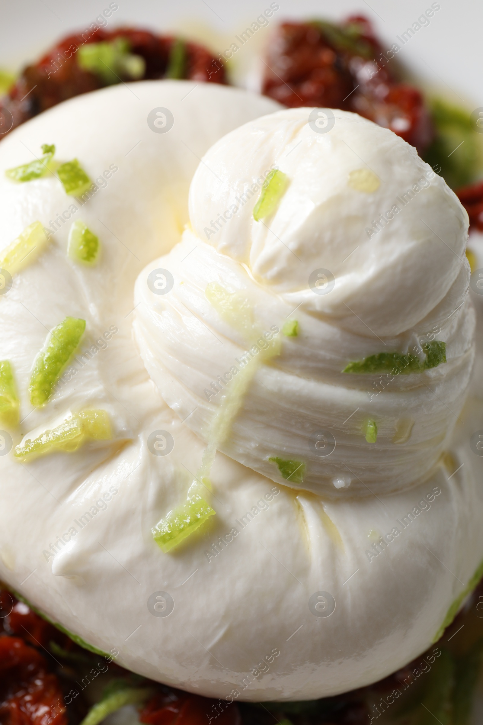 Photo of Delicious burrata cheese and sun-dried tomatoes on plate, closeup