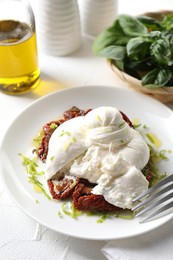 Photo of Delicious burrata cheese and sun-dried tomatoes served on white table, closeup